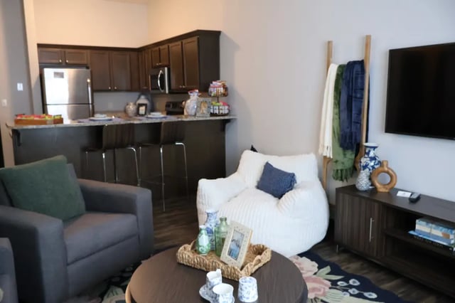 Chairs kitchen counter beanbag and TV living room at Bear Village Apartments in Springfield Student Accommodation