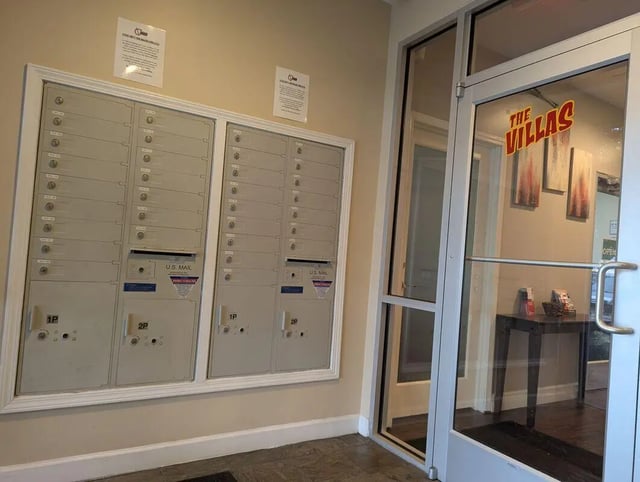 Mailboxes with number plates and door with signage exterior at Crimson Villas in Pittsburg Student Accommodation