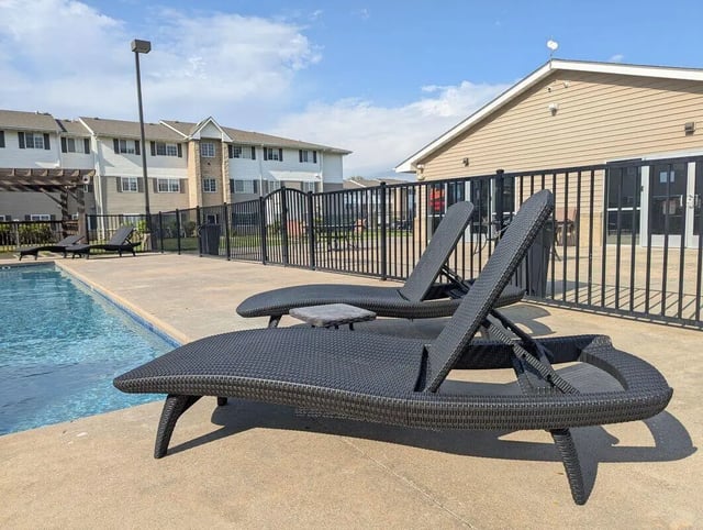 Poolside lounge chairs and pool exterior at Crimson Villas in Pittsburg Student Accommodation