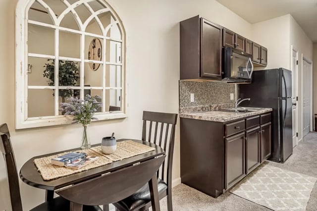 Table chairs books kitchen refrigerator kitchen at Eagle Summit Apartments in Cookeville Student Accommodation