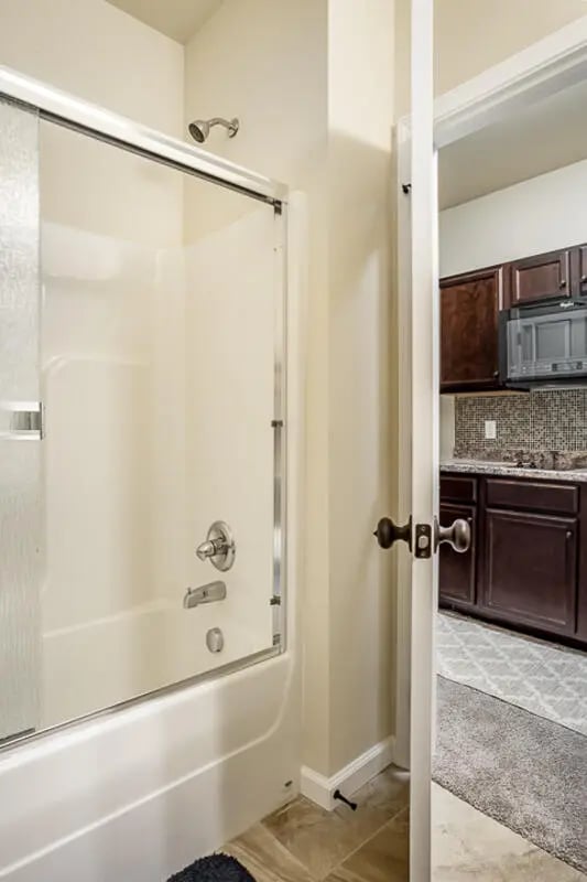 Shower tub kitchen visible through doorway bathroom at Eagle Summit Apartments in Cookeville Student Accommodation