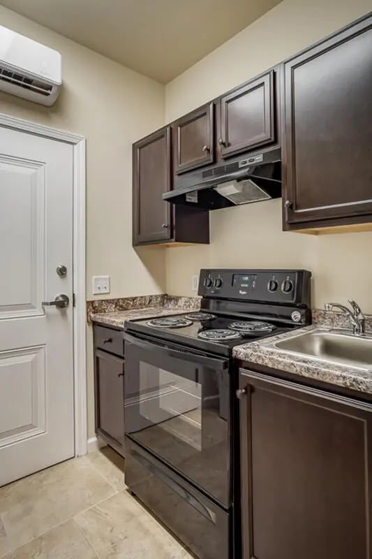 Dark cabinets stove sink AC kitchen at Eagle Summit Apartments in Cookeville Student Accommodation