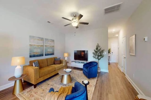 Sofa chairs coffee table television living room at 11 at Main in Winterville Student Accommodation