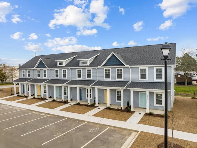 Townhouses with light blue siding and varied doors exterior at 11 at Main in Winterville Student Accommodation