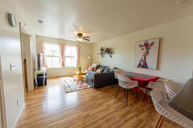 Sofa coffee table rug and dining table living room at 494 Lofts in Boone Student Accommodation