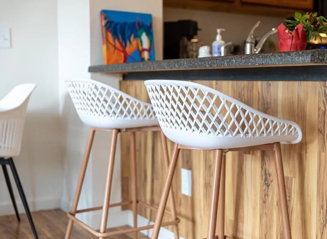 Two white bar stools and artwork kitchen at 494 Lofts in Boone Student Accommodation
