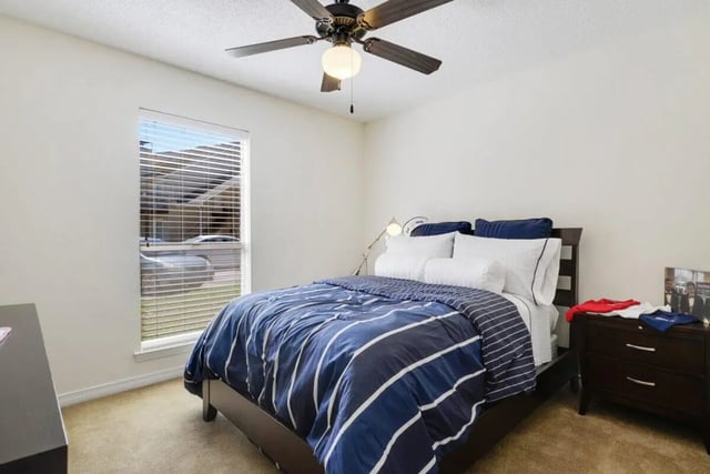 Bed with blue striped comforter white pillows bedroom at Beau Chene Condominiums, Inc in Baton Rouge Student Accommodation