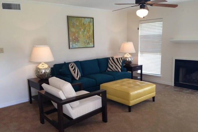 Blue sofa yellow ottoman white chair living room at Beau Chene Condominiums, Inc in Baton Rouge Student Accommodation