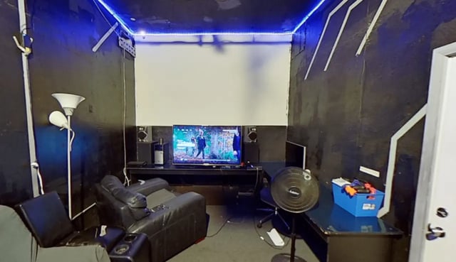 Black leather chairs TV speakers and fan living room at Artist Housing in Los Angeles Student Accommodation