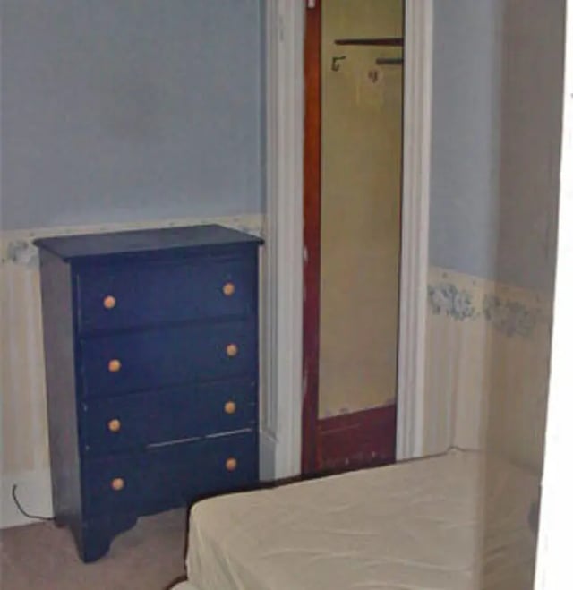 Dark blue dresser and bed bedroom at Copper Country Rentals in Houghton Student Accommodation
