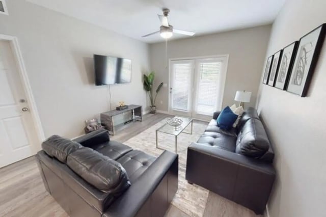 Black sofas TV glass coffee table living room at Altura Student Living in Tallahassee Student Accommodation