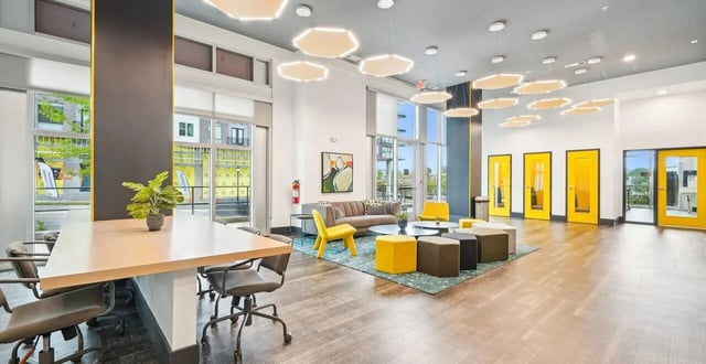 Lounge seating tables plant fire extinguisher yellow doors living room at Catalyst in Atlanta Student Accommodation