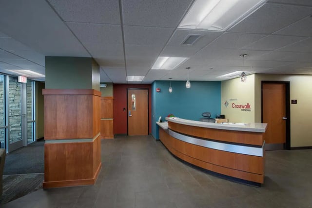 Curved reception desk wood paneling front desk area at Crosswalk Commons in West Lafayette Student Accommodation
