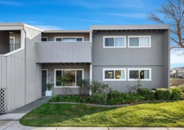 Gray building with balcony windows and lawn exterior at Aggie Square Apartments in Davis Student Accommodation
