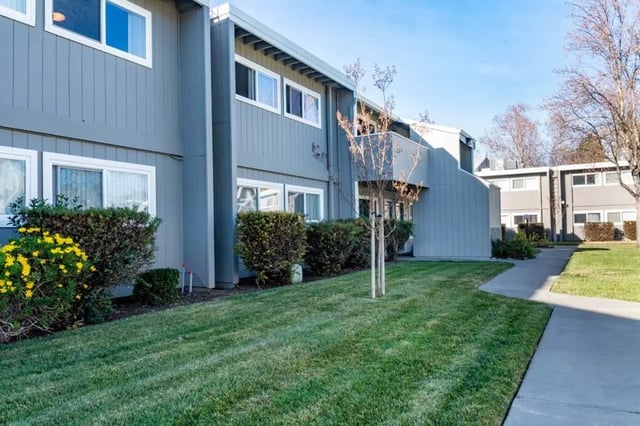 Apartment building with manicured lawn exterior at Aggie Square Apartments in Davis Student Accommodation