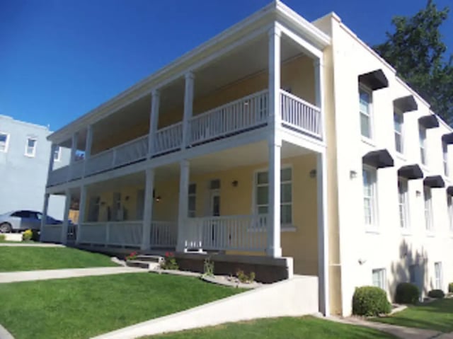 Yellow building with two balconies and awnings exterior at City Creek Manor in Salt Lake City Student Accommodation