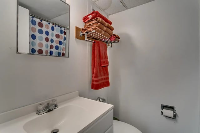 Sink mirror polka dot shower curtain towel rack bathroom at Cobblestone Court Apartments in Tuscaloosa Student Accommodation