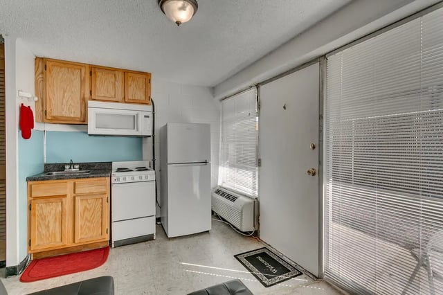 Kitchenette with fridge stove microwave cabinets kitchen at Cobblestone Court Apartments in Tuscaloosa Student Accommodation