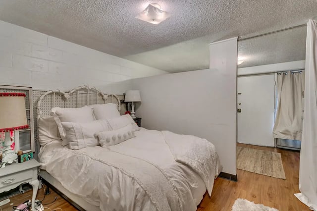 White bed white pillows bedside lamp bedroom at Cobblestone Court Apartments in Tuscaloosa Student Accommodation