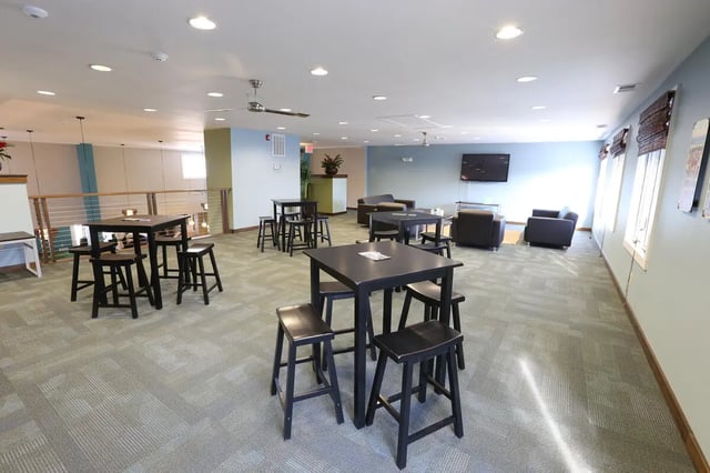 Modern common area with tables chairs and couches lounge at Collegiate Communities in West Lafayette Student Accommodation