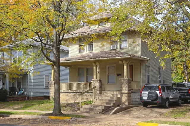 Two story house with porch and parked SUV exterior at Collegiate Communities in West Lafayette Student Accommodation