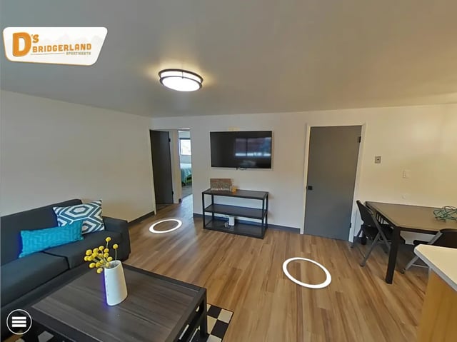Sofa TV dining table wooden floor living room at Bridgerland Apartments in Logan Student Accommodation