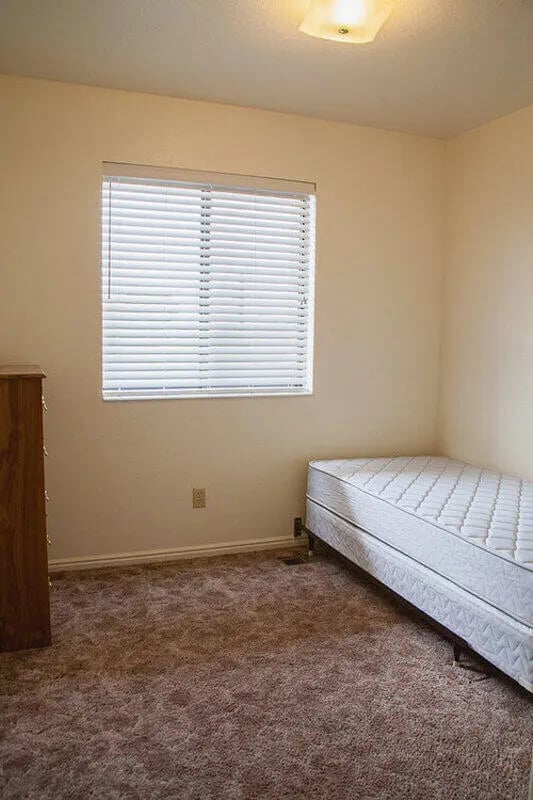 Bed dresser window light bedroom at Bridgerland Apartments in Logan Student Accommodation