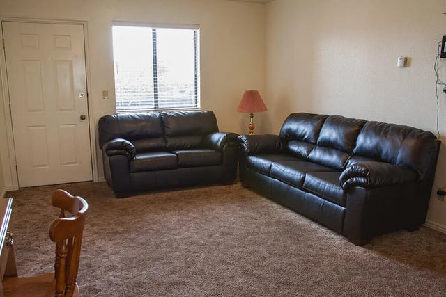 Two black sofas brown carpet living room at Bridgerland Apartments in Logan Student Accommodation