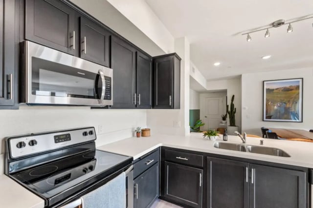 Stainless steel microwave dark cabinets stove sink kitchen at Ascent at Campus of Life in San Diego Student Accommodation
