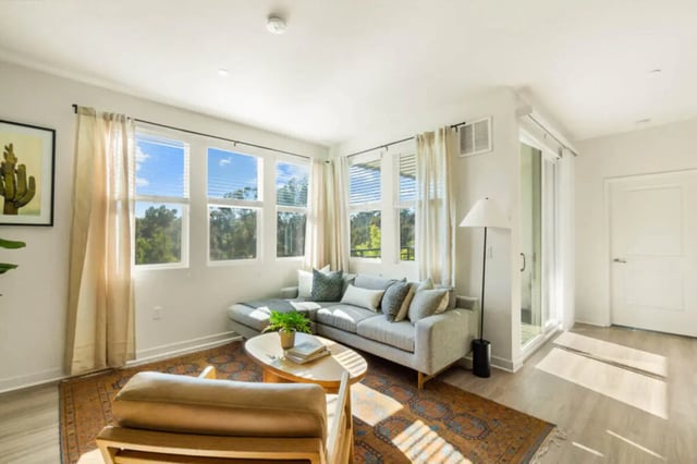 Grey sectional sofa oval coffee table living room at Ascent at Campus of Life in San Diego Student Accommodation
