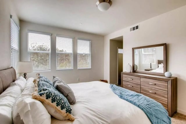 Bed dresser mirror and windows bedroom at Ascent at Campus of Life in San Diego Student Accommodation