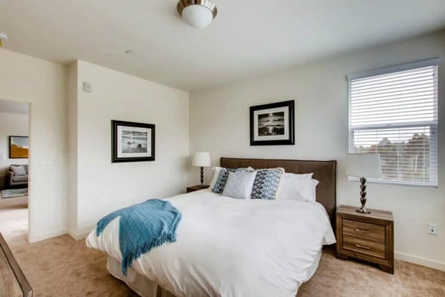 White bed blue blanket artwork nightstand bedroom at Ascent at Campus of Life in San Diego Student Accommodation