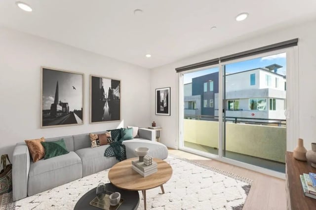 Grey sectional sofa with accent pillows living room at Ascent at Campus of Life in San Diego Student Accommodation