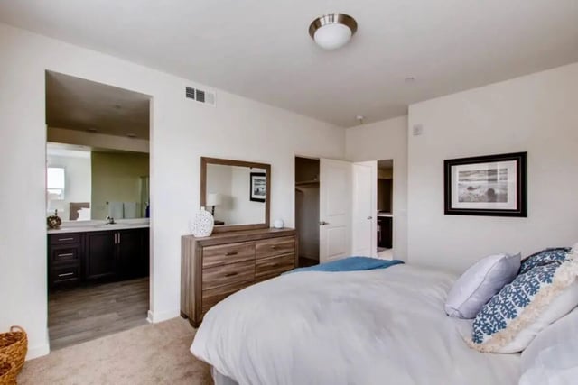 Bed dresser mirror open closet open door bedroom at Ascent at Campus of Life in San Diego Student Accommodation
