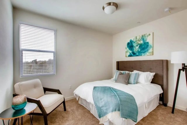 Bed with artwork chair and table bedroom at Ascent at Campus of Life in San Diego Student Accommodation