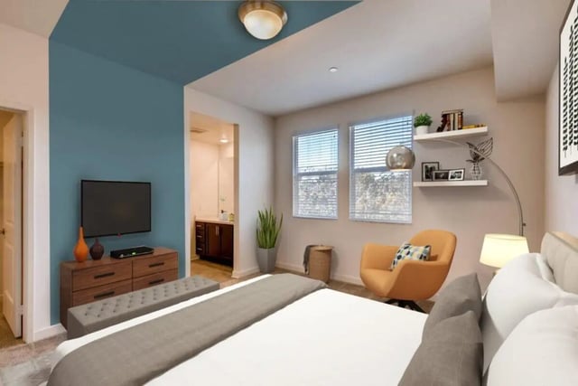 TV dresser bench orange chair windows bedroom at Ascent at Campus of Life in San Diego Student Accommodation