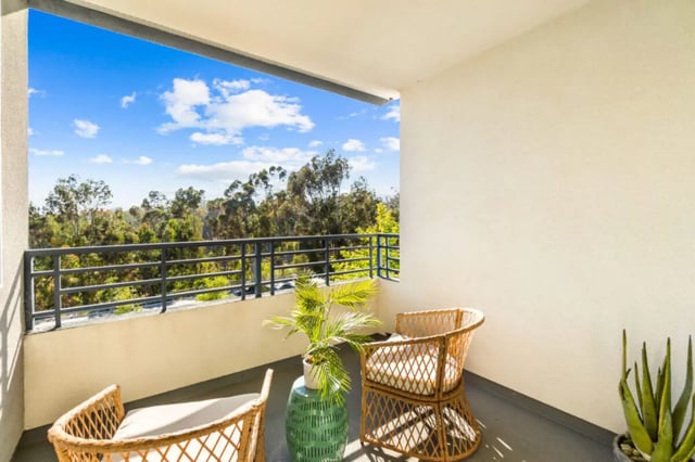 Wicker chairs green table plant balcony exterior at Ascent at Campus of Life in San Diego Student Accommodation