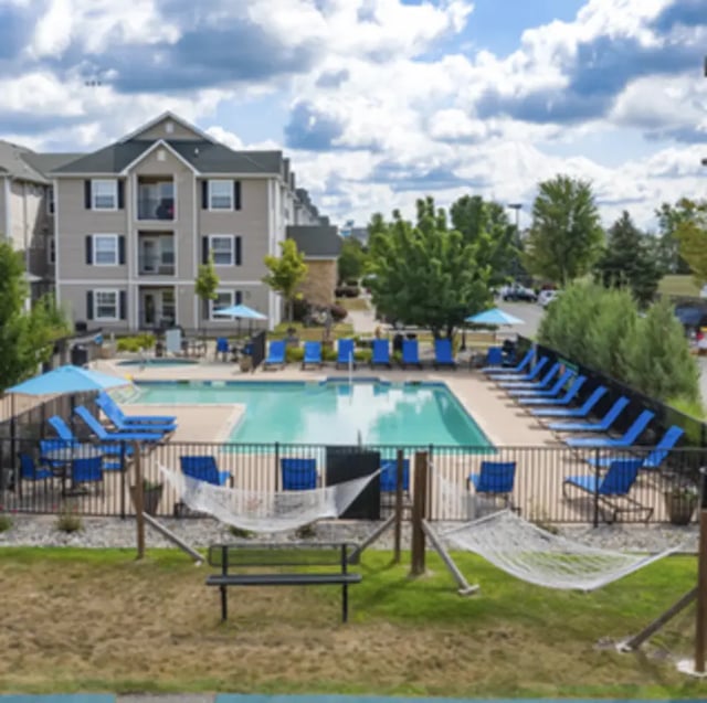 Apartment building pool lounge chairs hammocks playing area at Block 36 - Lease by Bed Available in East Lansing Student Accommodation