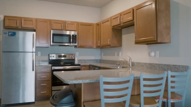 Stainless steel fridge microwave stove chairs kitchen at Campus Lake Apartments