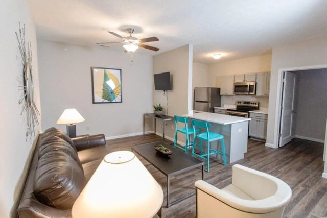Sofa table chairs kitchen appliances living room interior at 120 Flats in West Lafayette Student Accommodation