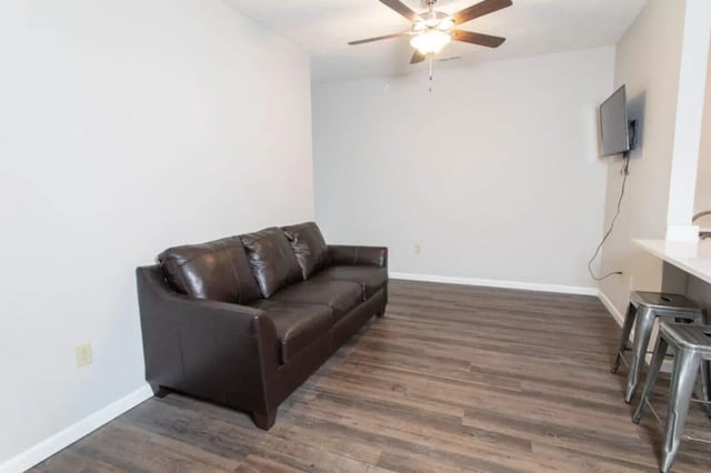 Brown leather couch ceiling fan television living room at 120 Flats in West Lafayette Student Accommodation
