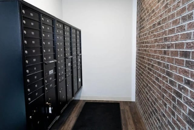 Mailboxes with numbered doors and brick wall hallway. at 120 Flats in West Lafayette Student Accommodation