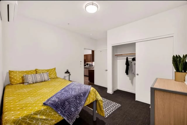 Bed with yellow linens and purple throw Bedroom at Cedar Flats Apartments in Chico Student Accommodation