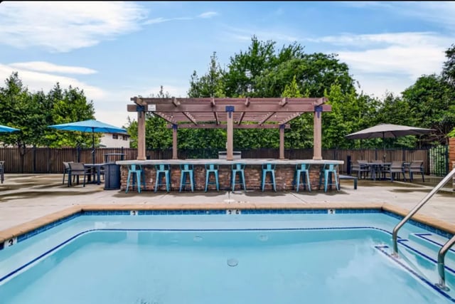 Bar stools and pool deck exterior at Cedar Flats Apartments in Chico Student Accommodation