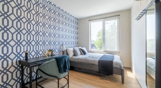 Bed desk chair and blue patterned wallpaper bedroom at 525 Linc in Boston Student Accommodation