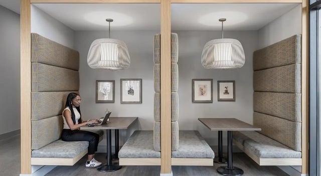Woman working at laptop in study booth study area at 525 Linc in Boston Student Accommodation