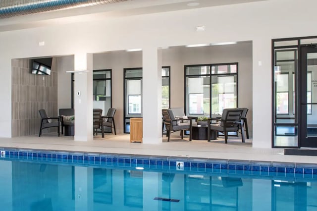 Chairs and tables around indoor pool. at Broadmoor Hills in Omaha Student Accommodation