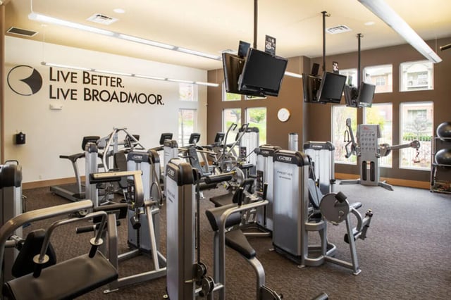 Gym equipment weight machines TVs clock exterior at Broadmoor Hills in Omaha Student Accommodation