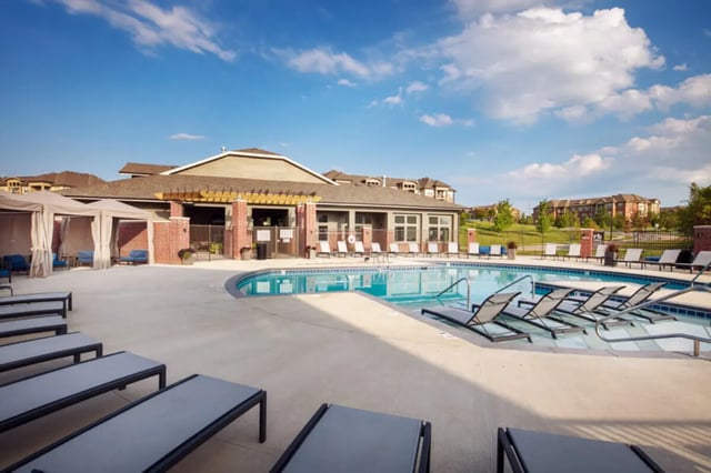 Pool lounge chairs cabanas and apartments exterior at Broadmoor Hills in Omaha Student Accommodation