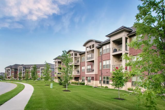 Apartment buildings with balconies and trees exterior at Broadmoor Hills in Omaha Student Accommodation